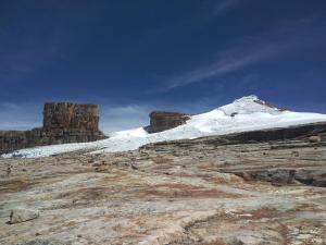 a snow covered mountain on top of a rocky mountain at El salto del gato in Güicán