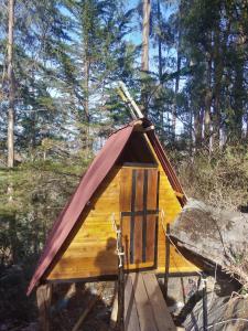 a small wooden teepee with a red roof at El salto del gato in Güicán