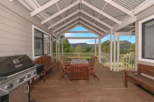 Wild Rose Cottage Kiaroo Estate, Kangaroo Valley في كانجرو فالي: شاشة في الشرفة مع طاولة وكراسي وشواية