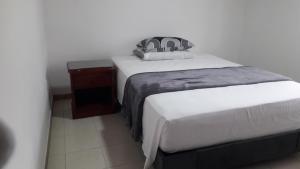 2 Einzelbetten in einem Zimmer mit einem Nachttisch in der Unterkunft Casa rural o chalet in Santa Rosa de Cabal