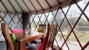 - une table et des chaises en bois dans une chambre avec fenêtre dans l'établissement Bay of Islands Holiday Park, à Paihia