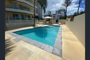a swimming pool in front of a building at Wyuna - Walking distance to burleigh in Gold Coast