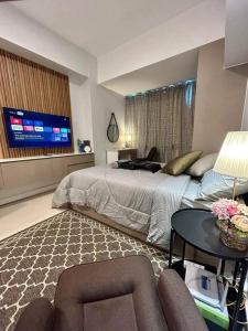 sypialnia z łóżkiem, stołem i telewizorem w obiekcie 38 Park Ave studio with gym, pool, fiber wifi w Cebu