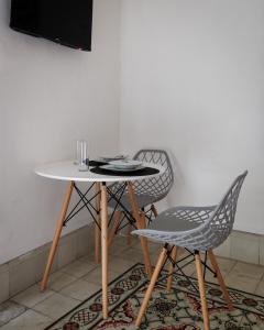 une table et deux chaises assises à côté d'une table blanche dans l'établissement CENTRO FRENTE CASA DE ARTESANIAS ESTUDIO4 CASA PAXI, à Mérida