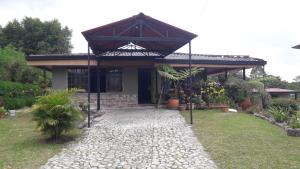 ein Haus mit einem steinernen Gehweg davor in der Unterkunft Casa rural o chalet in Santa Rosa de Cabal