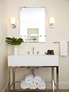
a white sink sitting under a mirror in a bathroom at The Island House in Nassau
