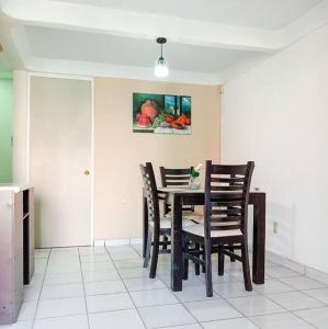 una sala da pranzo con tavolo, sedie e un quadro di Cómoda Casa 3Hab: Piscina, Seguridad, Parking a Emiliano Zapata
