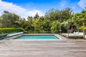 a swimming pool in a backyard with a wooden deck at Grey Lynn Luxury 4BD Villa w Pool Free Parking in Auckland