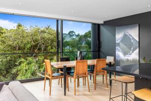 a dining room with a table and chairs and a large window at Grey Lynn Luxury 4BD Villa w Pool Free Parking in Auckland