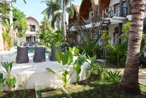 a resort with a table and pillows in a garden at My Gili Paradise in Gili Trawangan