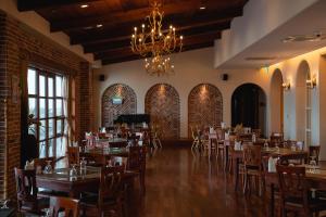 a dining room with tables and chairs and a chandelier at ArdenHill Resort & Golf in Jeju
