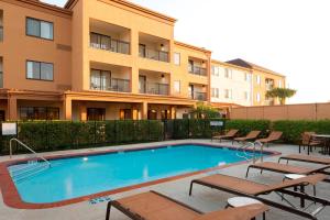 a swimming pool in front of a building at Courtyard by Marriott Brownsville in Brownsville