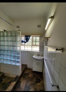 La salle de bains est pourvue d'un lavabo et d'une fenêtre. dans l'établissement R.KAWIMBE FURNISHED APARTMENTS, à Lusaka