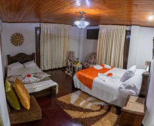 sypialnia z 2 łóżkami i kanapą w obiekcie HOTEL LA CASONA SAN AGUSTIn w mieście San Agustín