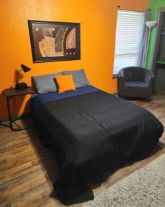 um quarto com uma cama grande e uma cadeira em COZY PRIVATE ROOM #2 em Dallas