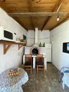 eine Küche mit einem Tisch, Stühlen und einer Mikrowelle in der Unterkunft Alojamiento Tres Lunas Triple in Chuy