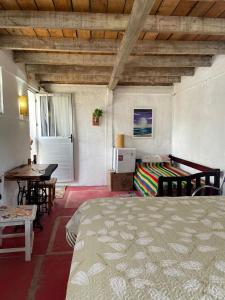 Schlafzimmer mit einem Bett, einem Schreibtisch und einem Tisch in der Unterkunft Alojamiento Tres Lunas Triple in Chuy