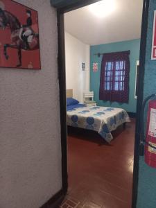 ein Schlafzimmer mit einem Bett und einem Bild eines Pferdes in der Unterkunft El Boquerón - Hospedaje in Huanchaco