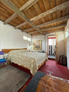 sypialnia z dużym łóżkiem i drewnianym sufitem w obiekcie Alojamiento Tres Lunas Triple w mieście Chuy