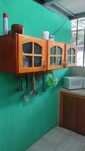 une cuisine avec un meuble en bois sur le mur dans l'établissement Kike, à Uvita