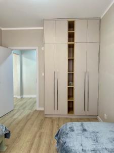 Buyan’s apartment في أولان باتور: غرفة نوم بها دواليب بيضاء وسرير
