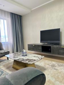 a living room with a tv and a coffee table at Buyan’s apartment in Ulaanbaatar