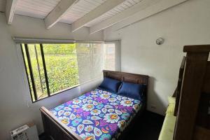 - un petit lit dans une chambre avec fenêtre dans l'établissement Villa Diana, Condominio Oasis, à Guayabal de Síquima