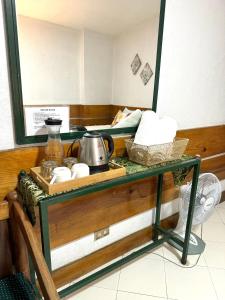 einen Tisch mit einem Spiegel und einen Wasserkocher in der Unterkunft Casa Generosa in Baguio City