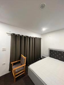 1 dormitorio con cama y silla de madera en Chubar home stay, en Leh