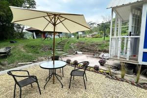 een tafel en stoelen met een parasol op een patio bij Tiny House On Wheels - Guayabal de Siquima in Guayabal de Síquima