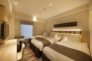 Postel nebo postele na pokoji v ubytování Hotel Sunroute Ginza
