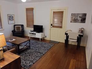 una sala de estar con un televisor y una mesa en Cajun Stays-Cajun Home II- Entire House, en Lafayette