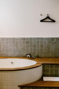 a bathroom with a bath tub and a sink at Brown Feather Hotel in Seminyak