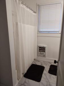 a bathroom with a white shower curtain and a window at Cajun Stays-Cajun Home II- Entire House in Lafayette