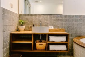 uma casa de banho com um lavatório e um balcão com toalhas em Brown Feather Hotel em Seminyak