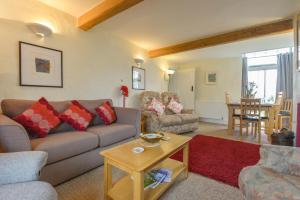 a living room with a couch and a table at Regatta Cottage in Feock