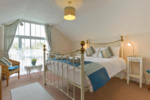 1 dormitorio con cama con dosel y ventana en Regatta Cottage en Feock