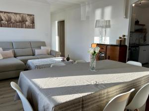 una sala de estar con una mesa con un jarrón de flores. en Magnifique appartement devant la plage, en Propriano