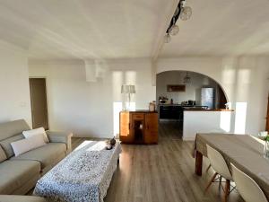 ein Wohnzimmer mit einem Sofa und einem Tisch in der Unterkunft Magnifique appartement devant la plage in Propriano