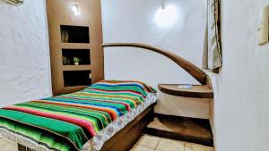 a small room with a bed and a sink at Hostal ROCA INN in Mazatlán