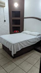 a bed in a room with a white bedsheet at Hostal ROCA INN in Mazatlán