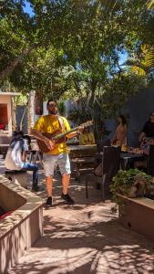 a man is playing a guitar on the sidewalk at Hostal ROCA INN in Mazatlán