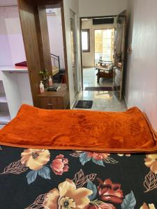 an orange rug on the floor of a room with a living room at 1 Bedroom & Living Room for Friends & Families in Chāmundi