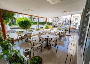 restauracja ze stołami i krzesłami w pokoju w obiekcie AKÇAY LEMAN OTEL w mieście Edremit