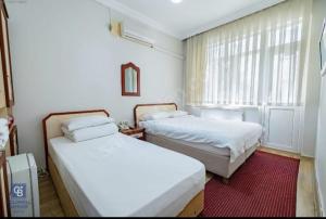 sypialnia z 2 łóżkami i oknem w obiekcie AKÇAY LEMAN OTEL w mieście Edremit