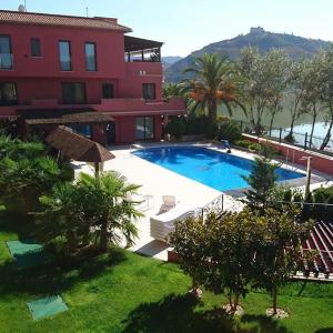a resort with a swimming pool in front of a building at Ebro Fishing Exlusiv Appartment in Mequinenza
