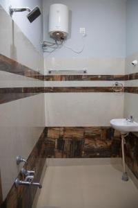 uma casa de banho com um lavatório, um WC e um espelho. em JK Resort em Yercaud