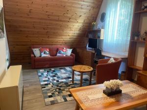 sala de estar con sofá rojo y mesa en Katarina's cozy bungalov, en Bad Mitterndorf