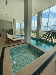 una piscina en un edificio con una palmera en Apto Lujoso, piscina climatizada, jacuzzi, gym. en Asunción
