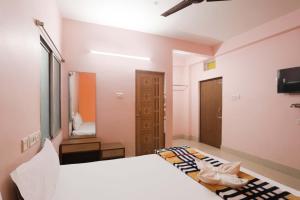 a bedroom with a large white bed and a mirror at Hotel shivangi ECO in Puri